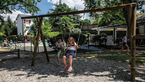 Une aire de jeux avec des balançoires et un espace de repos abrité.
