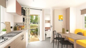 Une cuisine moderne équipée d’un four à micro-ondes encastré, un coin repas avec une table et des chaises en bois, et un canapé jaune.