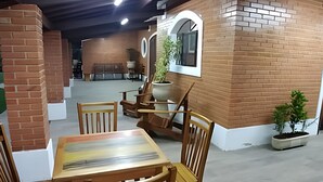 Un espacio interior amplio con paredes de ladrillo, muebles de madera y plantas en macetas.