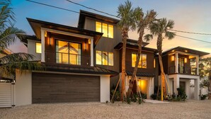 A modern two-story house with a garage, large windows, and a well-maintained lawn.