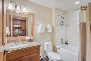 Une salle de bain avec un lavabo, des toilettes et une baignoire.