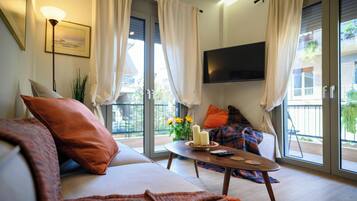 A modern living room with a sofa, a coffee table, and a TV mounted on the wall.
