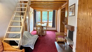 A cozy cabin with a loft bedroom, a wooden staircase, a dining area, and a fireplace. - 200m from resort center, view forest, terrace, balcony, fireplace or stove, tv, 42m², La Plagne (La Plagne)