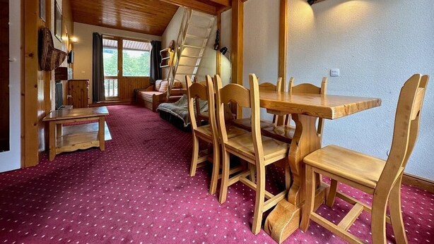 A wooden interior with a dining table and chairs, a sofa, and a staircase. - 200m from resort center, view forest, terrace, balcony, fireplace or stove, tv, 42m², La Plagne (La Plagne)