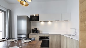 A modern kitchen with wooden cabinets, a built-in oven, and a sink. - Apartment in La Rosiere With Stunning Alpine Views (Montvalezan)
