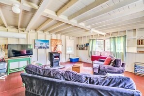 Una sala de estar con sofá, televisor, chimenea y estantería.