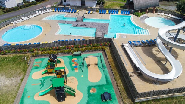 A pool area with multiple swimming pools, a children's play area, and a water slide. - Cocooning Tipi - Azur (Azur)