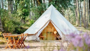 A white tent with a table and chairs outside, surrounded by trees. - Cocooning Tipi - Azur (Azur)