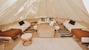 A cozy tent with two beds, a central seating area, and a small stool. - Cocooning Tipi - Azur (Azur)