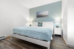 Une chambre à coucher avec un lit, des tables de chevet et un tableau au mur.