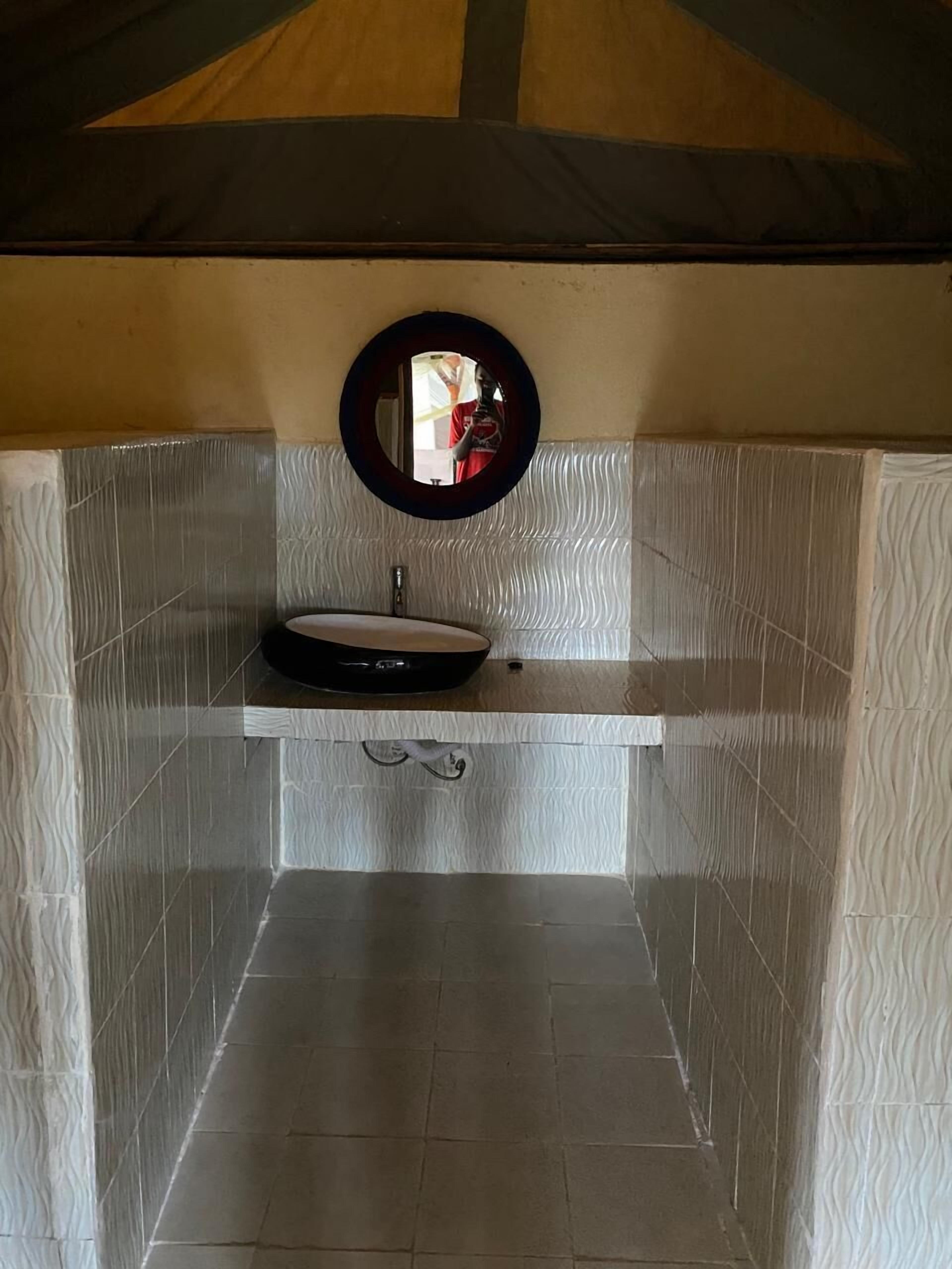 A bathroom with a sink, mirror, and towel rack.
