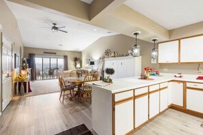 Una cocina moderna con una isla central, armarios de madera e iluminación colgante.