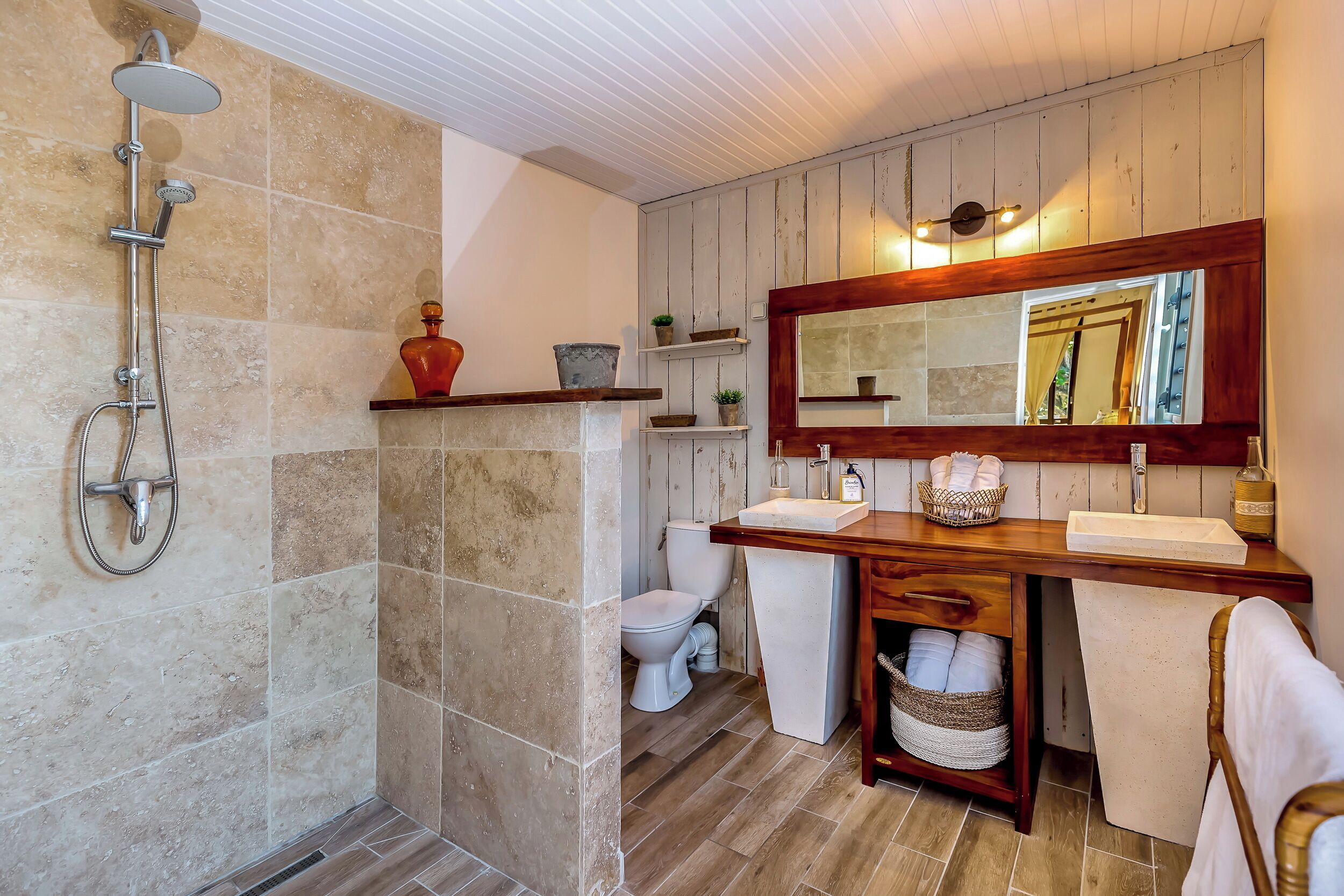 A bathroom with a shower, toilet, and vanity with a mirror.
