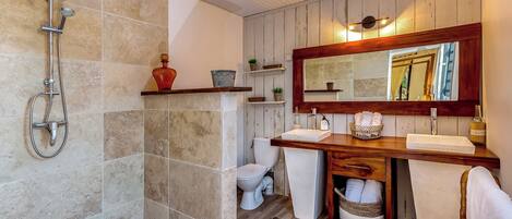 A bathroom with a shower, toilet, and vanity with a mirror.