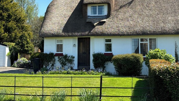 A traditional thatched-roof cottage with a white exterior, a dark wooden door, and a small window above the door. - Thatched Cottage - Sleeps 6 With Countryside Views (Dorchester)