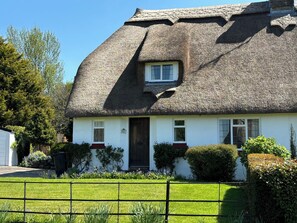 A traditional thatched-roof cottage with a white exterior, a dark wooden door, and a small window above the door. - Thatched Cottage - Sleeps 6 With Countryside Views (Dorchester)