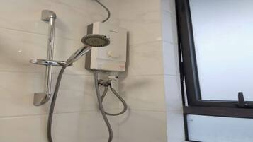 Een douche met een handdouche en een douchekop, aangesloten op een bedieningspaneel dat aan de muur is bevestigd.