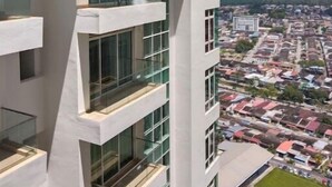 Un edificio moderno de gran altura con varios balcones y ventanas amplias.
