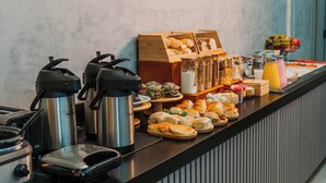 Montaje de bufé con diferentes platillos y máquinas de café.