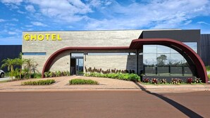 Un hotel moderno con una entrada curva y un letrero grande que dice 'HOTEL'.