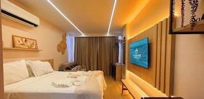 A hotel room with a bed, bedside table, TV, and a wall-mounted artwork. - Setai Yacht Luxo - By Almare Flats (Joao Pessoa)