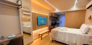 A modern hotel room with a large bed, a desk, a TV, and a bathroom visible through a door. - Setai Yacht Luxo - By Almare Flats (Joao Pessoa)