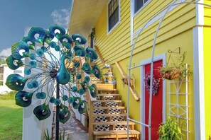 Welcome to a lively and artistic haven with a unique metal sculpture and traditional wooden staircase.