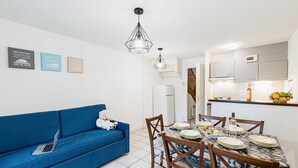 A modern kitchen with white cabinets, a built-in oven, and a fruit bowl on the counter. - Duplex 8p • Réserve naturelle | Piscine incluse (Le Teich)