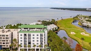 Een kusthotel met meerdere gebouwen, een golfbaan en een waterlichaam.