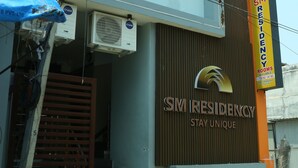 Un immeuble de deux étages avec une enseigne indiquant « SM Residency ».