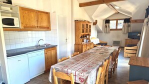 A cozy kitchen with wooden cabinets, a white dishwasher, and a dining table with chairs.