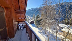 A wooden balcony with a view of snow-covered mountains and trees. - 100m from ski slopes, 2nd floor, balcony, ski locker, 90m², Valfréjus (Valfréjus)
