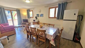 A cozy dining area with a table, chairs, and a refrigerator. - 100m from ski slopes, 2nd floor, balcony, ski locker, 48m², Valfréjus (Valfréjus)