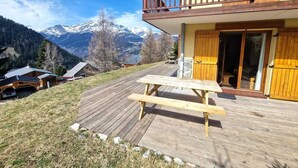 A wooden deck with a picnic table, a wooden balcony, and a mountain view. - 100m from ski slopes, terrace, ski locker, 48m², Valfréjus (Valfréjus)