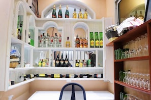 A bar area with shelves of liquor bottles and glasses. - Hotel Residence Madadjeu (Yaoundé)