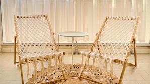 Two woven rattan chairs with a small round table in between, set on a woven mat. - Apartment with balcony - sea view (Canet-en-Roussillon)