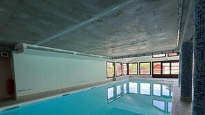 An indoor swimming pool with clear blue water, large windows, and a tiled floor. - 140m from ski slopes, 2nd floor, view mountain, balcony, ski locker, 37m², Flumet (Flumet)
