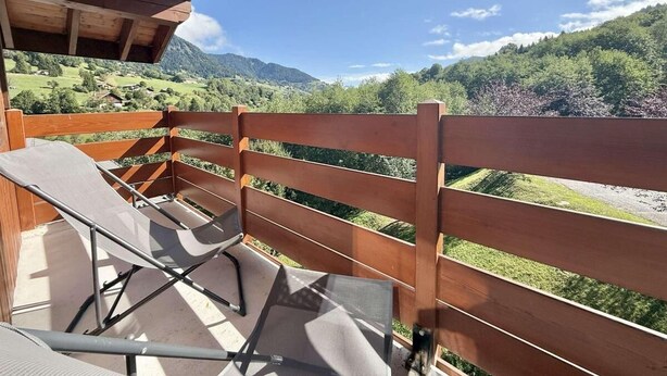 A balcony with a wooden railing, a folding chair, and a view of a mountainous landscape. - 140m from ski slopes, 2nd floor, view mountain, balcony, ski locker, 37m², Flumet (Flumet)