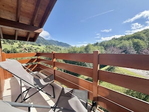 A balcony with a wooden railing, a folding chair, and a view of a mountainous landscape. - 140m from ski slopes, 2nd floor, view mountain, balcony, ski locker, 37m², Flumet (Flumet)