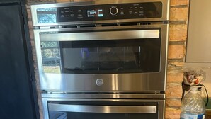 A kitchen with a stainless steel oven and a black refrigerator. - Sunset Drive! (Wewoka)