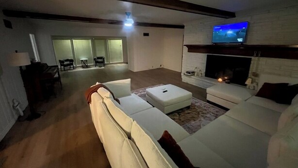 A modern living room with a fireplace, a television, and a seating area with sofas and a coffee table. - Sunset Drive! (Wewoka)