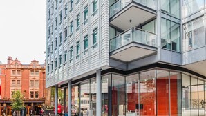 Ein modernes Gebäude mit Glasfassade und einem Café im Erdgeschoss.