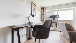 A modern room with a desk, two chairs, a large window, and a balcony. - Blueground | Bayswater, balcony & w/d, nr parks (London)