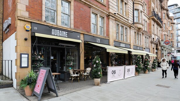 A row of storefronts with the number 129, including a restaurant named 'Aubaine'. - Blueground | Bayswater, balcony & w/d, nr parks (London)