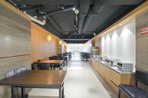 A modern restaurant interior with tables and chairs, a counter, and a view through the window. - Tianhe Express Hotel (Shenyang Middle Street Forbidden City) (Shenyang)