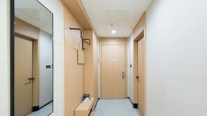 A narrow hallway with a bench, a mirror, and a door at the end. - Tianhe Express Hotel (Shenyang Middle Street Forbidden City) (Shenyang)