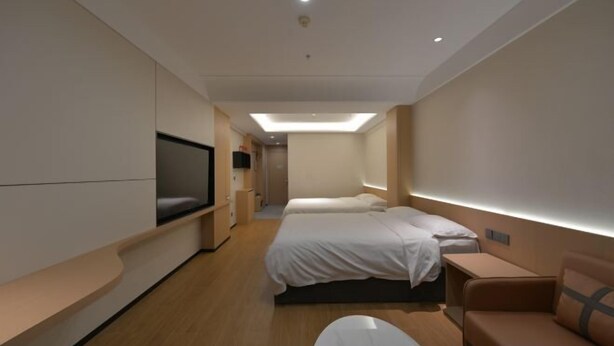 A modern hotel room with a large bed, a sofa, a TV, and a desk. - Tianhe Express Hotel (Shenyang Middle Street Forbidden City) (Shenyang)