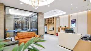 A modern reception area with a leather sofa, a reception desk, and a glass wall. - Tianhe Express Hotel (Shenyang Middle Street Forbidden City) (Shenyang)
