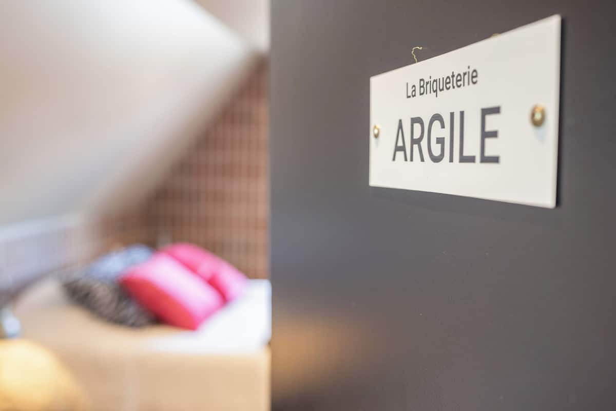 A sign with the text "La Briqueterie ARGILE" on a wall.
