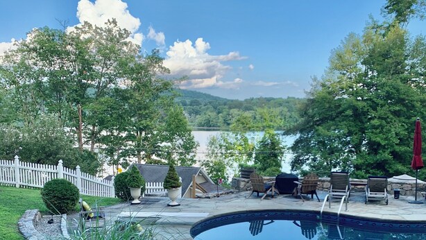 A backyard with a swimming pool, surrounded by grass, trees, and a white picket fence. - Charming Grand View/Lake Loft in Brewster with WiFi, AC (Brewster)